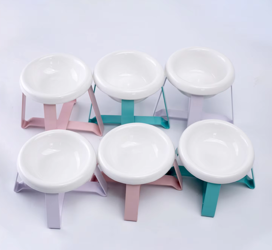 White dog bowl in a raised metal stand providing a comfortable feeding height for pets