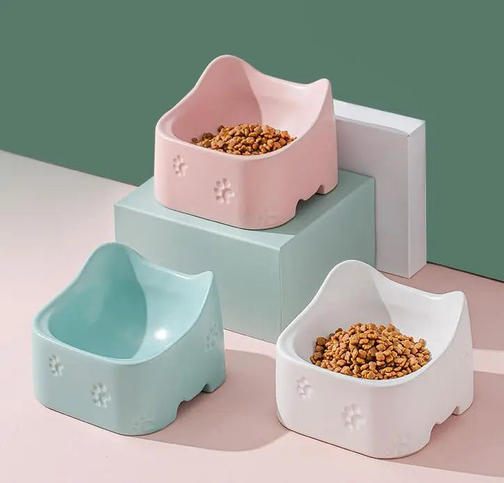 Two raised pet bowls, one black and one white, for cats, featuring an ergonomic feeding height