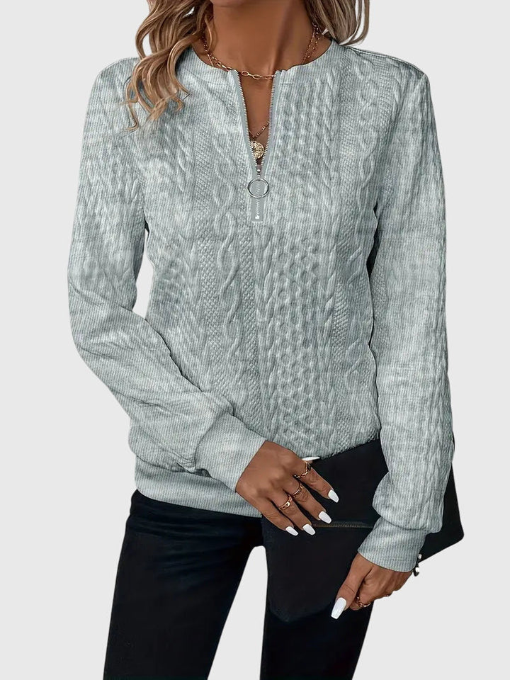 Woman smiling in a white Harlow cable knit quarter-zip sweater. Casual, cozy fall fashion.