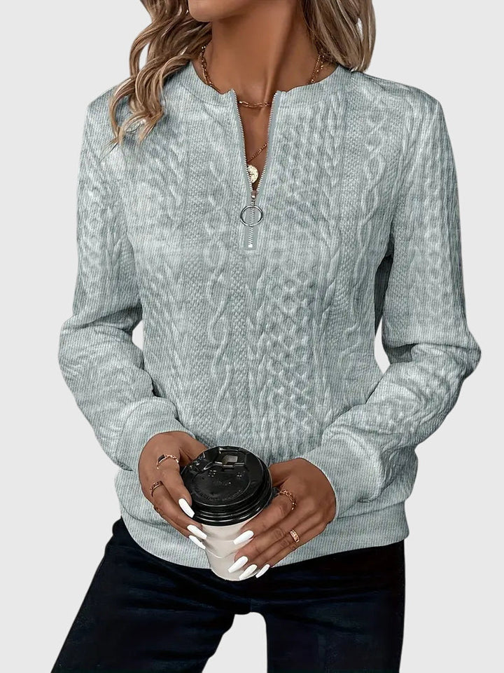 Side view of a grey women's cable knit quarter-zip sweater. Harlow pullover for winter comfort.