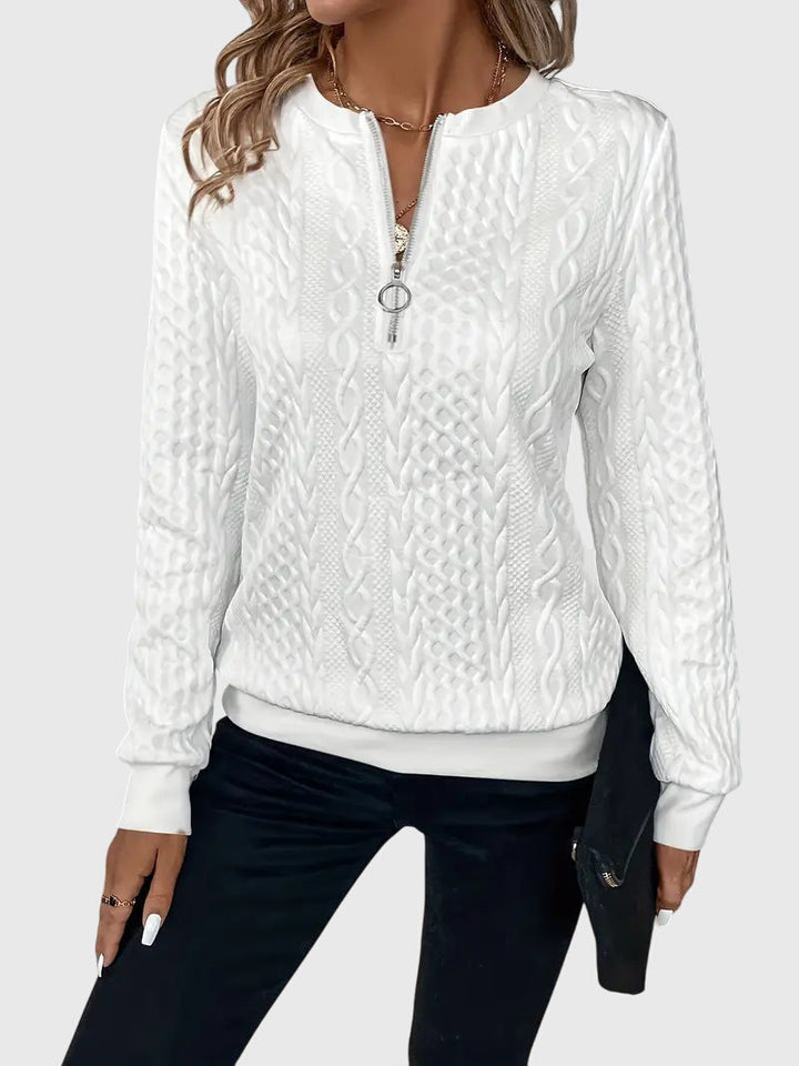Woman wearing a grey cable knit quarter-zip sweater, Harlow style. Casual & warm fall fashion.