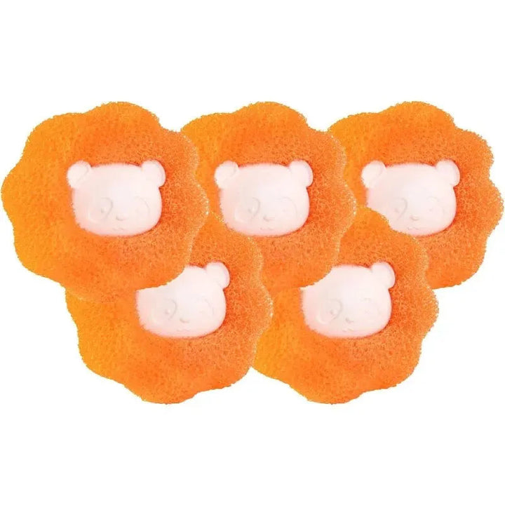 White reusable pet hair remover laundry balls with collected lint, shown in a washing machine.