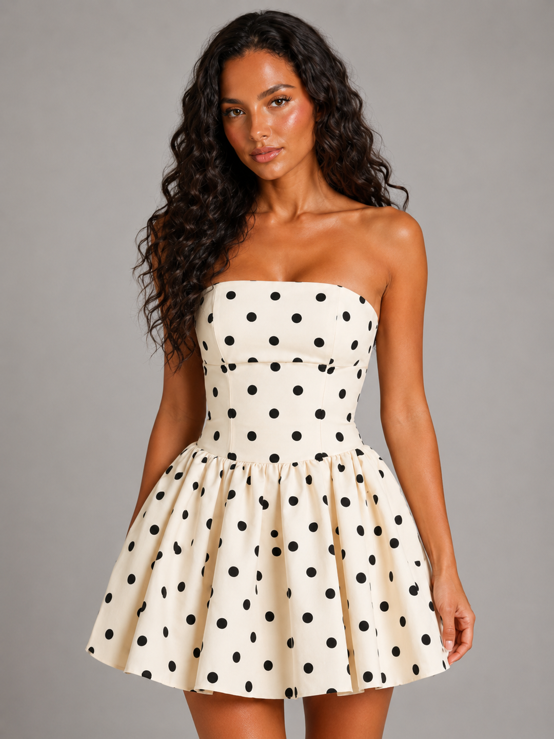 Close-up of the polka dot pattern and corset lacing on a chic white strapless mini dress.