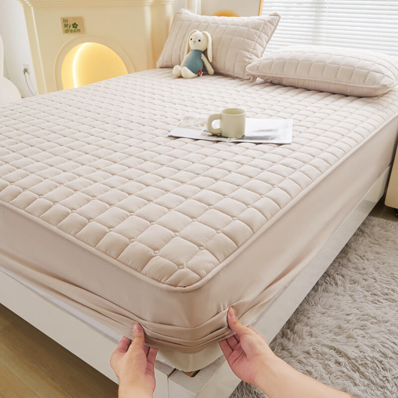 Side view of a mattress with a waterproof protector, highlighting its slim profile under sheets.