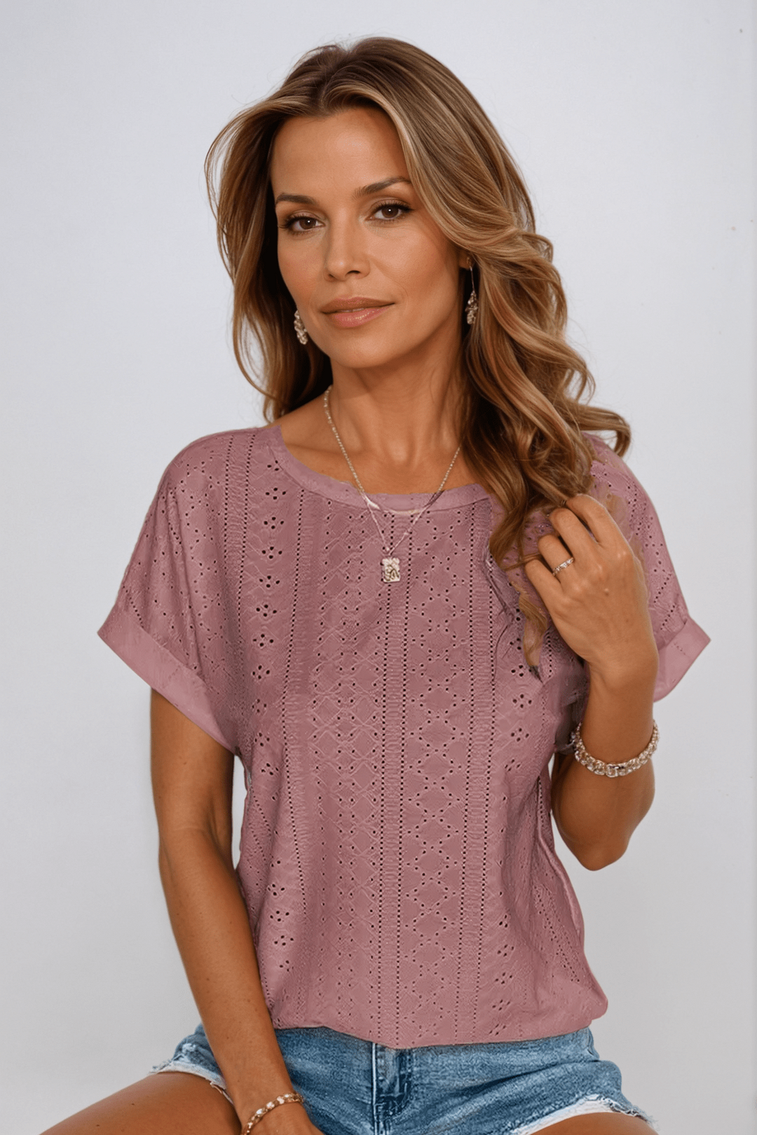 Casual chic women's white crew neck top with delicate eyelet embroidery. Loose fit, short sleeve summer blouse.