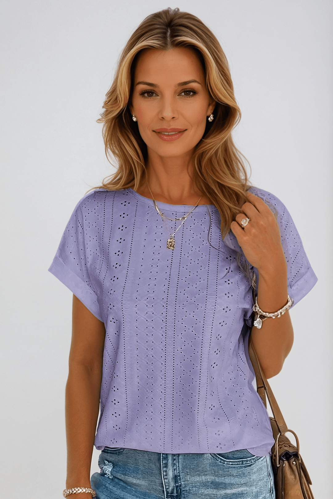 Elegant women's eyelet embroidered short sleeve top. White crew neck blouse, ideal for summer outfits.