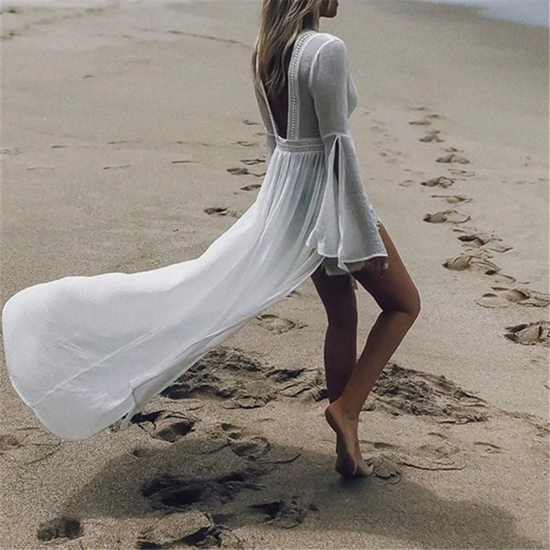 Comfortable women's flowy white maxi dress with open back & chic flare sleeves, great for beach days.