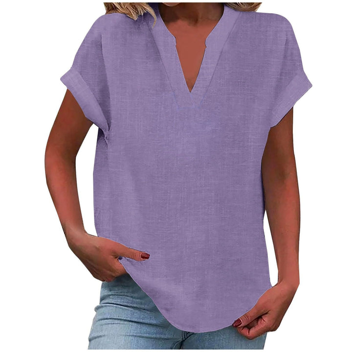 Woman in white relaxed fit V-neck blouse, showcasing fabric & flattering neckline. Effortless style.