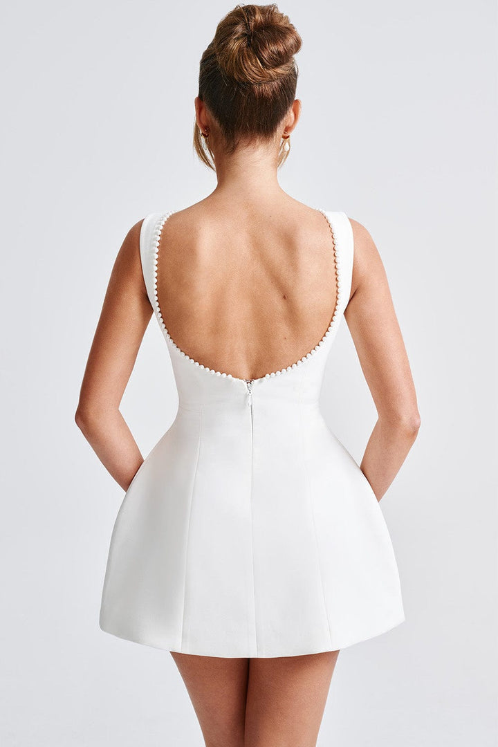Chic fashion A-line mini dress for women, featuring delicate pearl trim and a bold statement back bow.