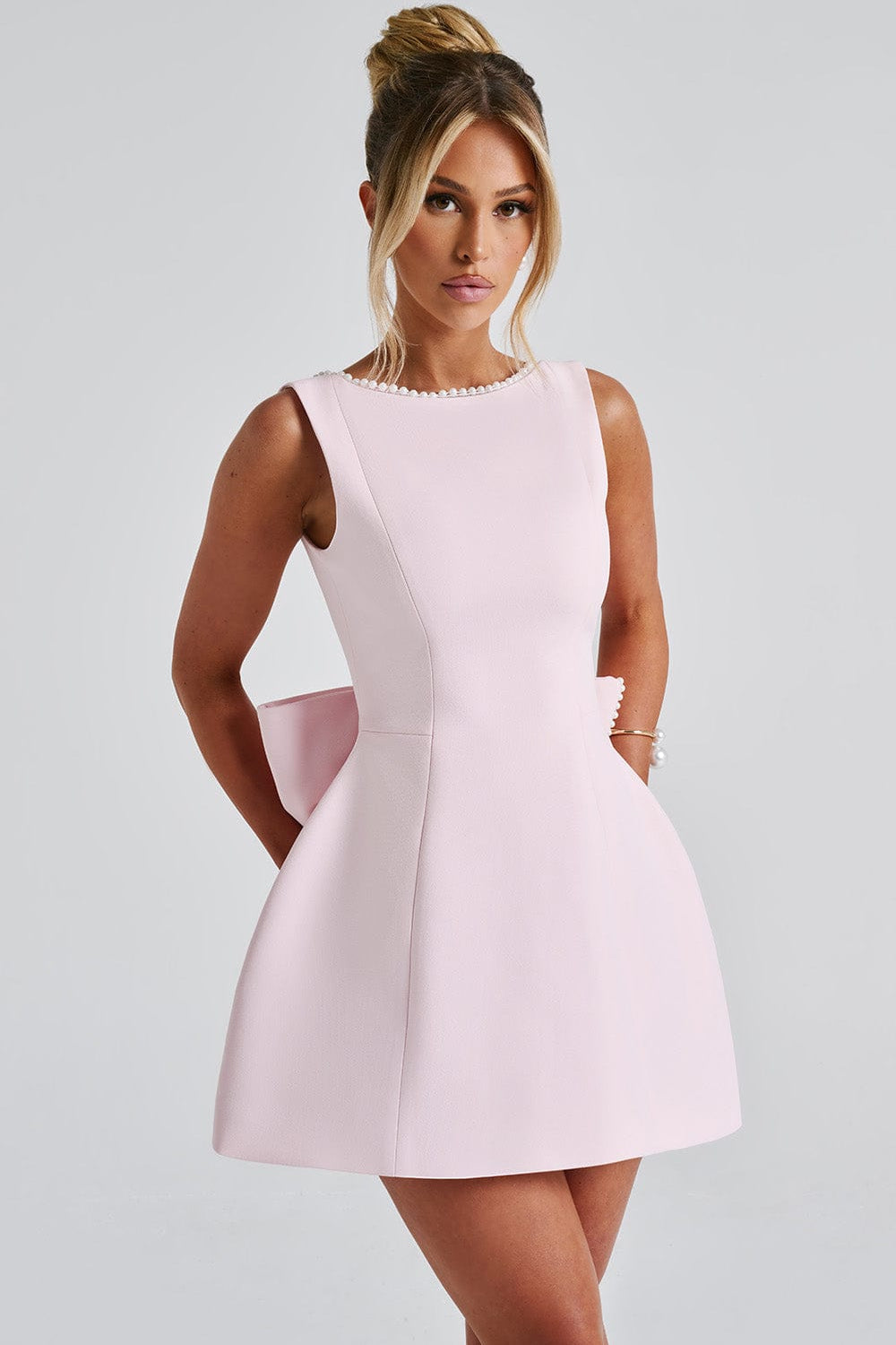 Stylish women's mini dress, A-line cut with beautiful pearl trim and an eye-catching statement back bow.