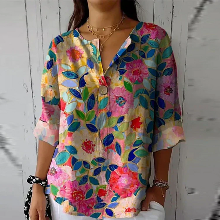 Stylish women's abstract floral V-neck blouse, relaxed fit for summer. Statement top with vibrant print & 3/4 sleeves.