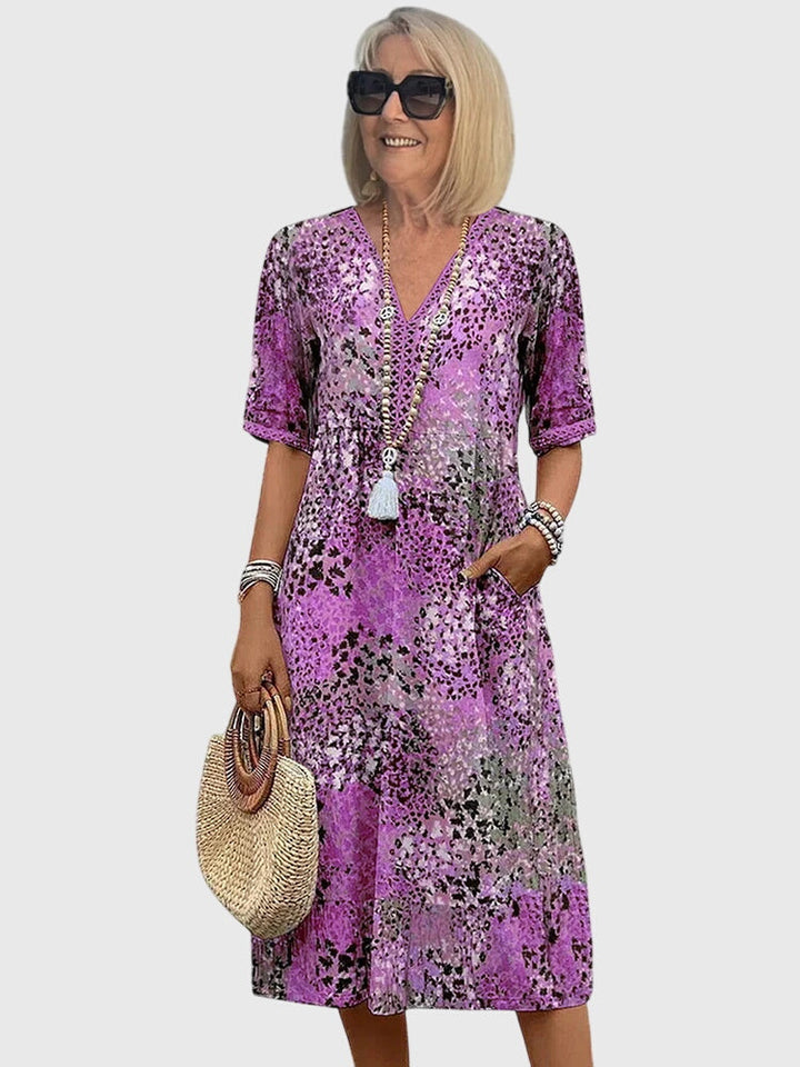 Detailed abstract floral print on a women's boho V-neck midi summer dress, featuring flowy flutter sleeves.