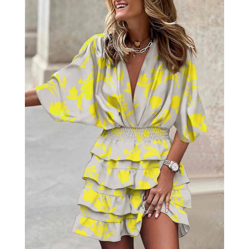 Vibrant women's abstract print smocked mini dress with tiered ruffles, batwing sleeves, and a flattering V-neck.