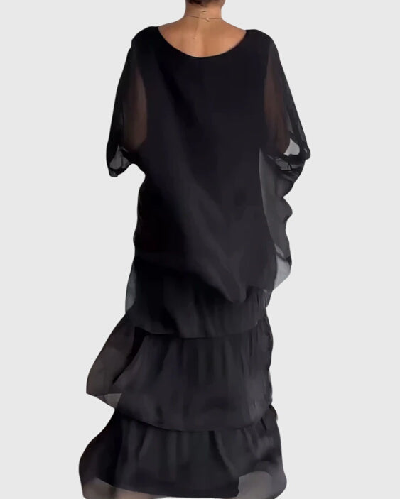 Elegant women's abstract print maxi dress with batwing sleeves, tiered boho flowy design.
