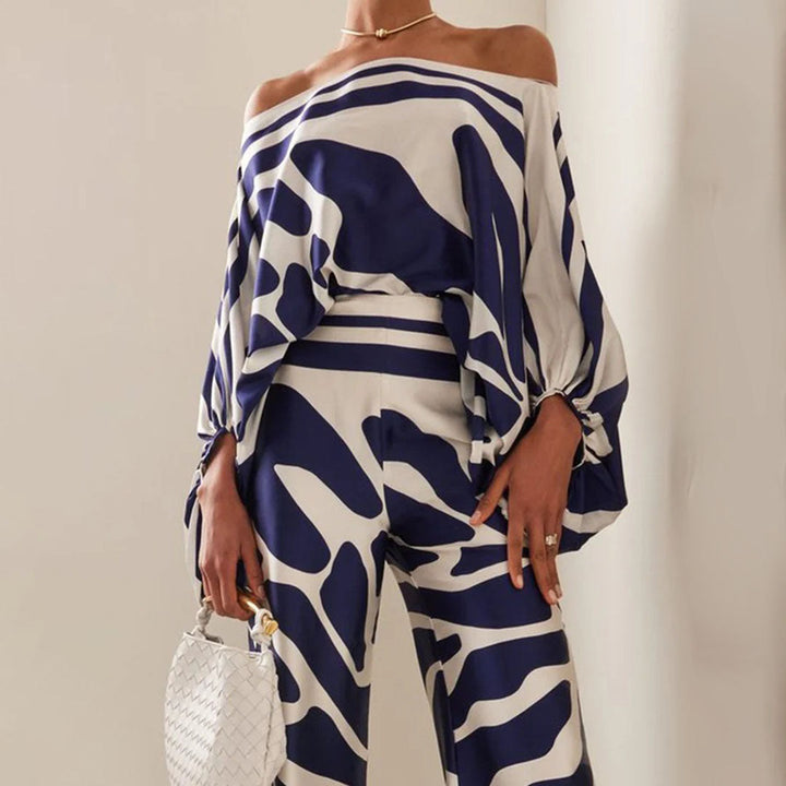 Chic one-shoulder top and matching high-waisted wide-leg printed pants set for women. Perfect vacation outfit.
