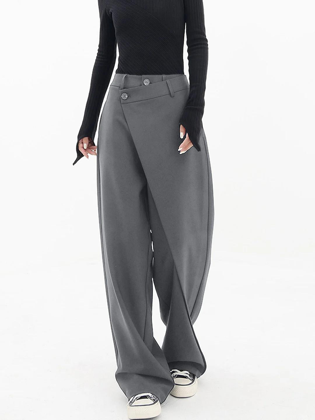Close-up of the asymmetric detail on women's relaxed fit baggy trousers, showcasing unique modern style.