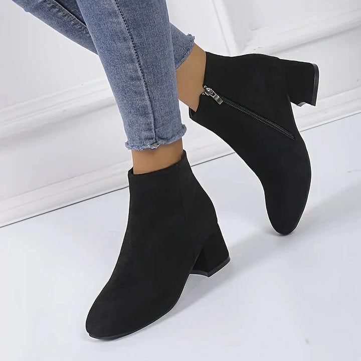 Elegant black women's ankle boots featuring a sturdy block heel and functional side zip for easy wear.