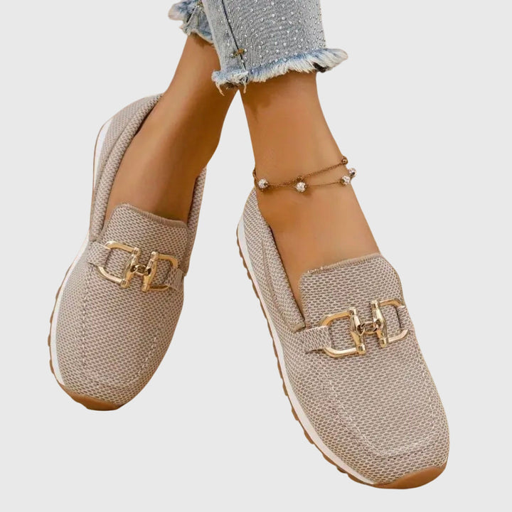 Elegant women's slip-on loafers in black with a stylish metal accent, versatile for everyday & comfort.