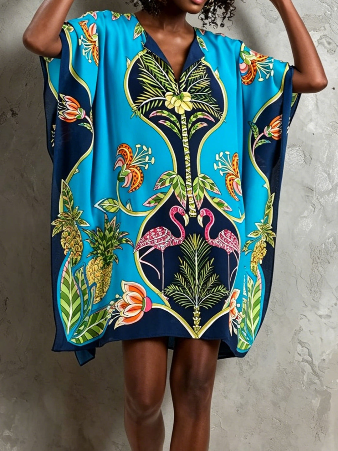 Elegant women's blue tropical midi dress with a V-neck and batwing sleeves. Relaxed fit for summer fashion.