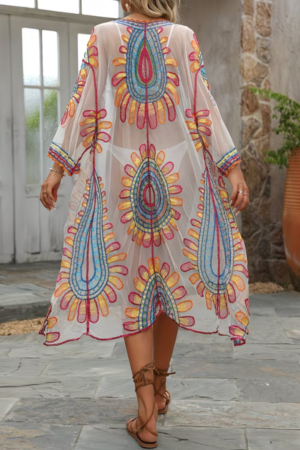 Woman wearing a stylish bohemian kimono beach cover up with sunflower details, perfect for summer resort wear.