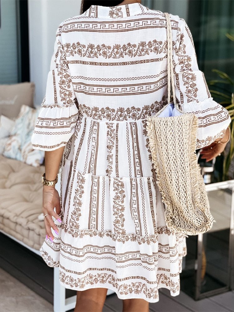 Spring/summer bohemian tiered mini dress for women, flowy and relaxed fit, with elegant flare sleeves.