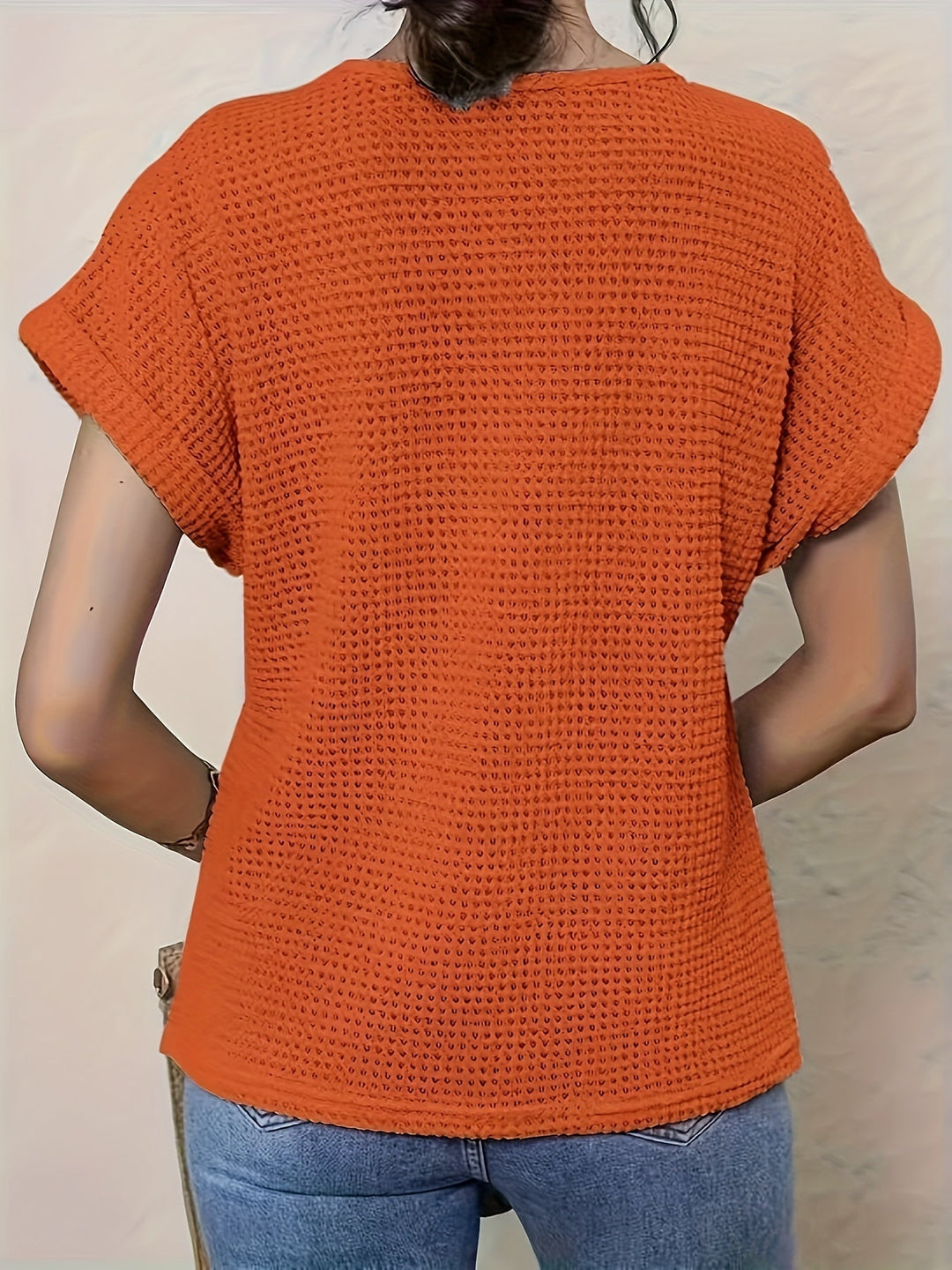 Intricate crochet detail on a women's boho casual top. Short sleeve, relaxed fit, summer chic.
