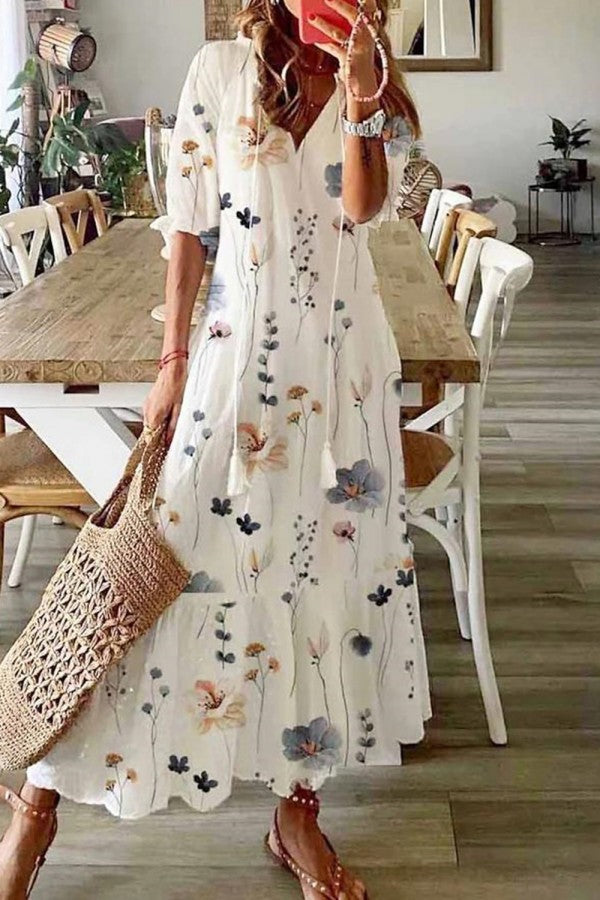Women's boho floral maxi dress with v-neck and tassel details, perfect for summer vacation or festival wear.