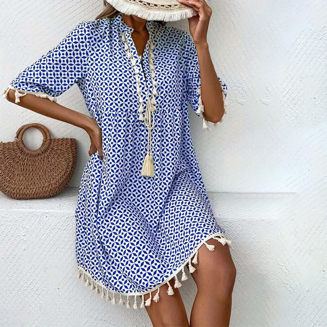Women's boho mini dress with tassel trim, short sleeves, and V-neck. Perfect for summer casual wear.