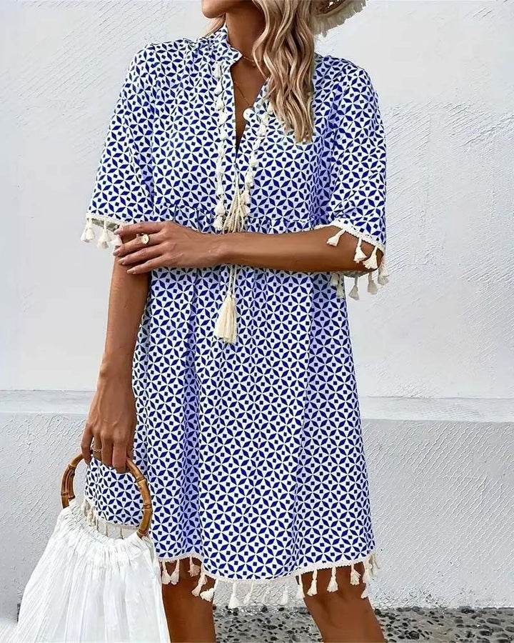 Stylish women's short sleeve mini dress, featuring a playful tassel trim. Perfect casual summer outfit.
