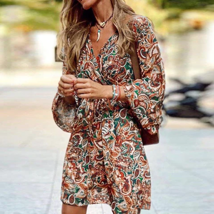 Comfortable women's bohemian paisley print mini dress. Features a smocked bodice, V-neck, & chic lantern sleeves.