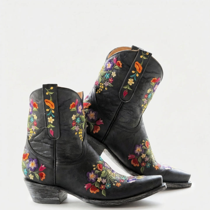 Close-up of intricate floral embroidery detailing on women's western ankle boots.