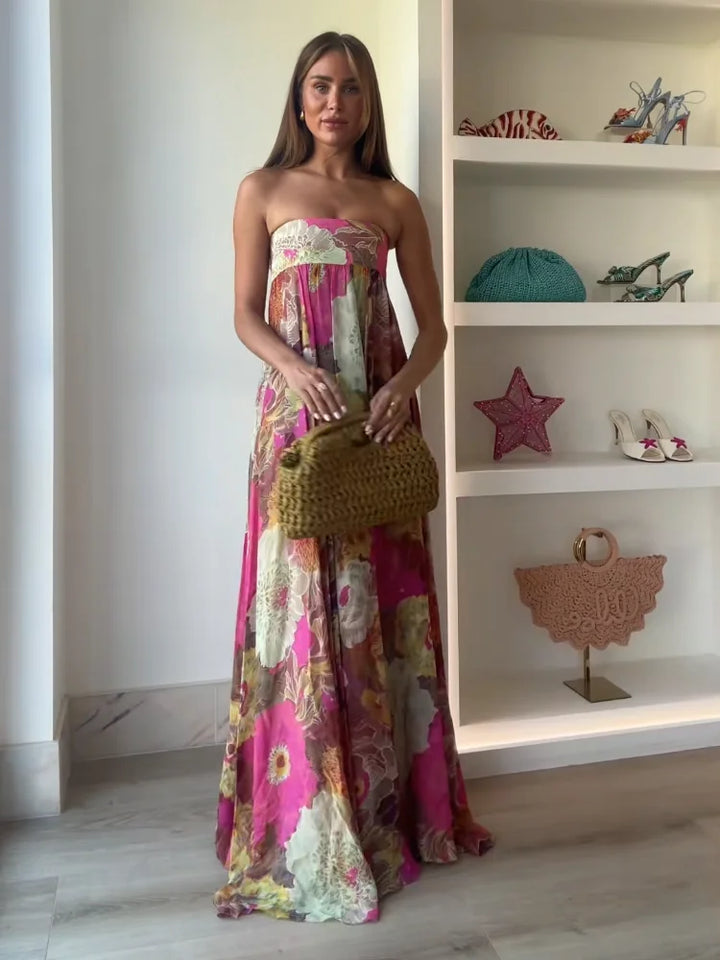 Stunning summer wedding guest dress: strapless, flowy, and vibrant bold floral maxi design.