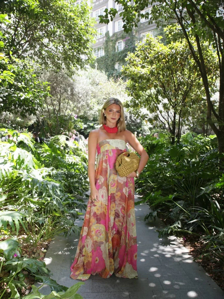 Flowy empire waist strapless maxi dress with bold floral print, perfect summer wedding guest outfit.