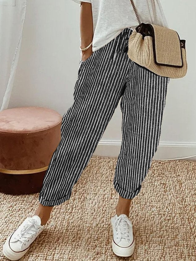 Woman walking in full-length moisture-wicking comfort pants, ideal for active, everyday wear.