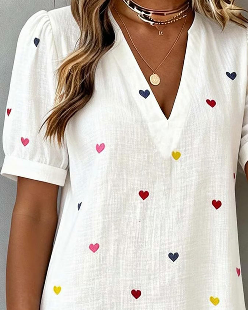 Stylish women's summer dress with an all-over heart print, elegant V-neckline, and trendy puff sleeves.