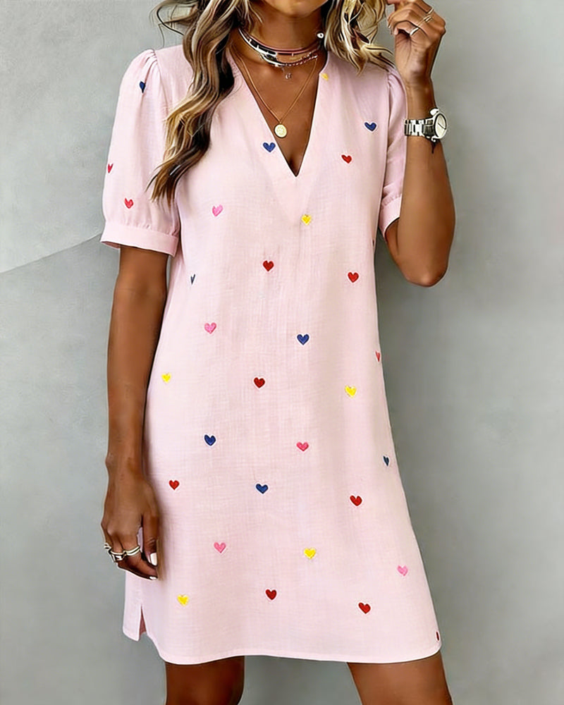 Cute women's casual dress with a vibrant heart print, V-neck, and chic puff sleeves for warm weather.