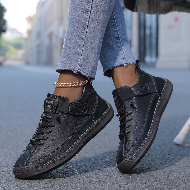Close-up of women's low-top casual sneakers featuring intricate stitched details and classic lace-up design.