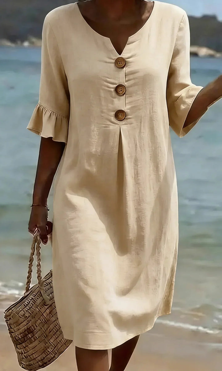 Woman in a flowy ruffle sleeve button-front midi dress, perfect for summer vacation and beach wear.