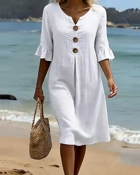 Detail of ruffle sleeves & button-front on a women's flowy casual midi dress. Feminine summer style.
