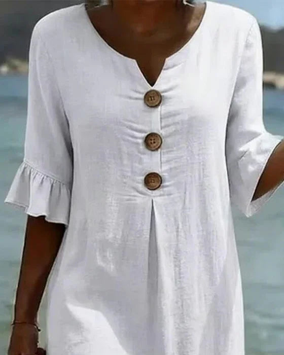Woman wearing a relaxed fit ruffle sleeve button-front midi dress, ideal for beach, summer or vacation.