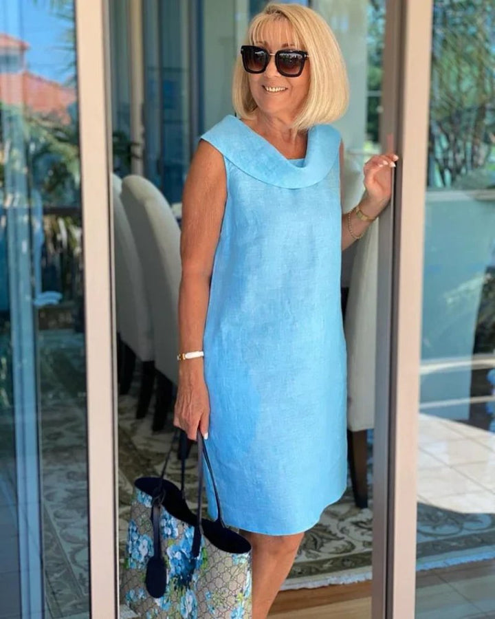 Relaxed fit women's knee-length shift dress with cowl neck and pockets, ideal for brunch or summer vacation.