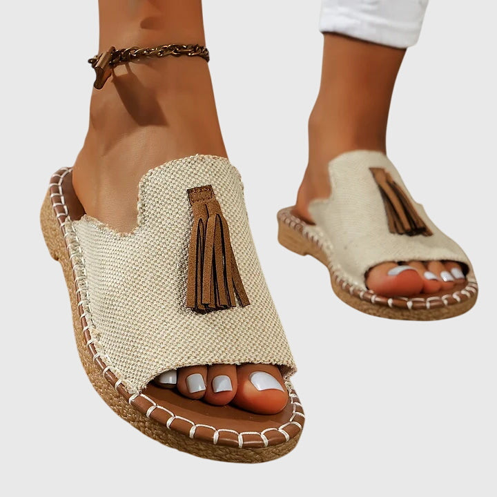Women's casual flat sandals with decorative tassel straps, easy slip-on for summer wear.