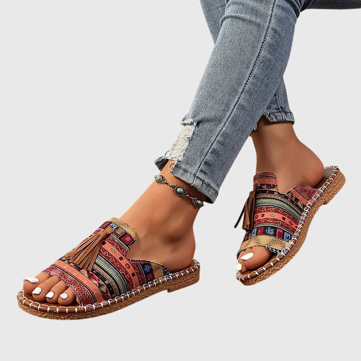 Stylish women's slip-on sandals with tassel straps & flat sole, comfortable for summer casual wear.