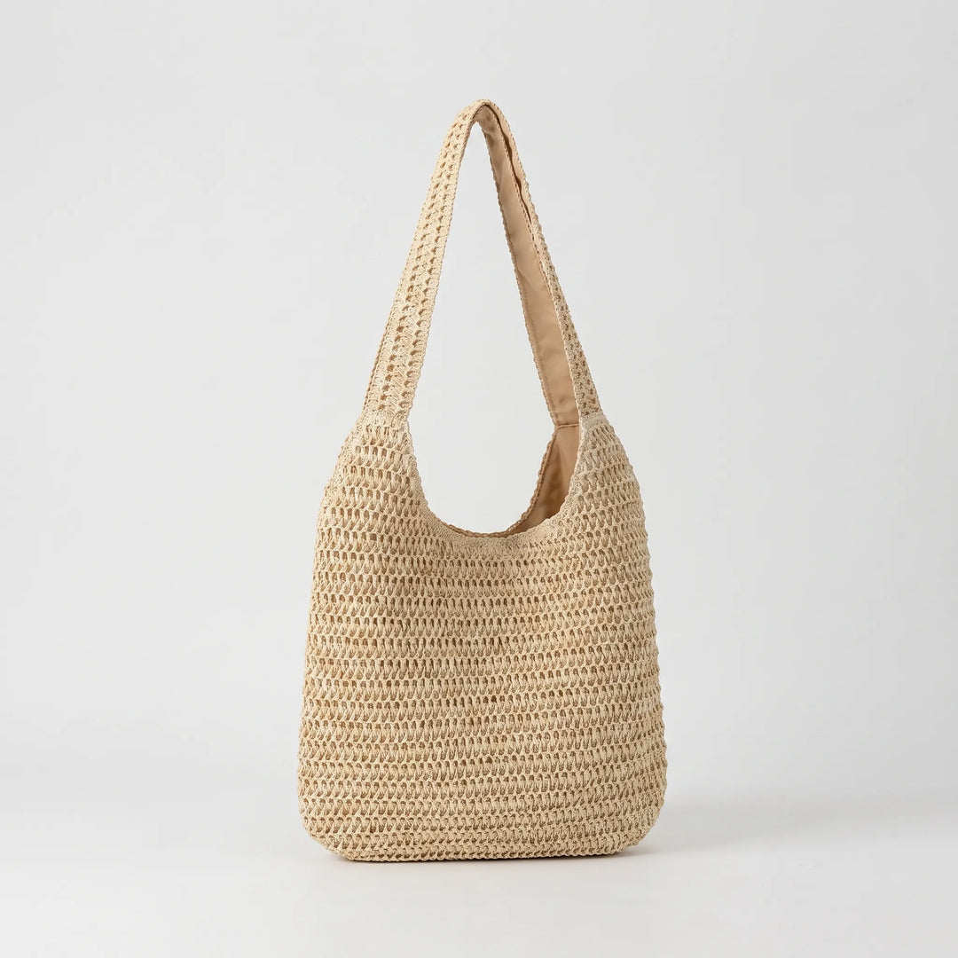 Fashionable woven tote bag for women, ideal as a casual shoulder bag or summer accessory. Relaxed style.