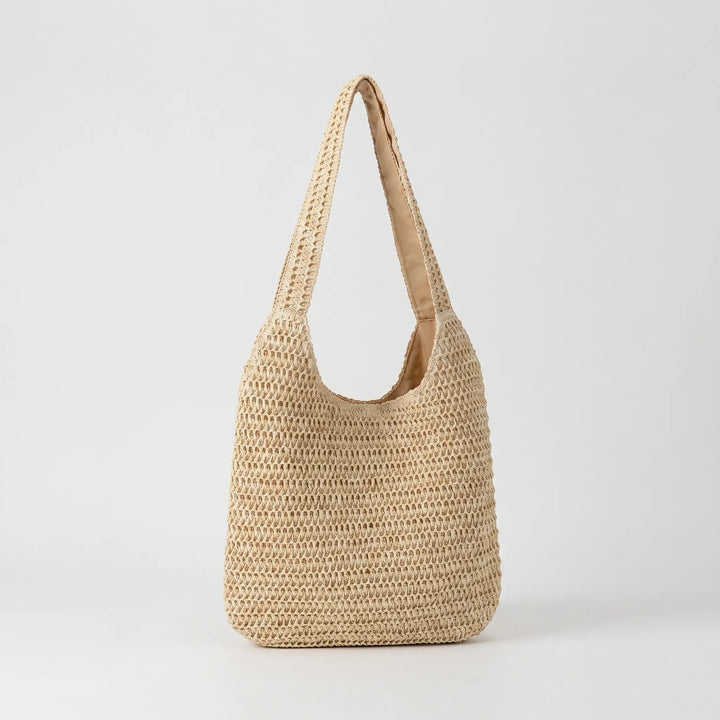 Fashionable woven tote bag for women, ideal as a casual shoulder bag or summer accessory. Relaxed style.