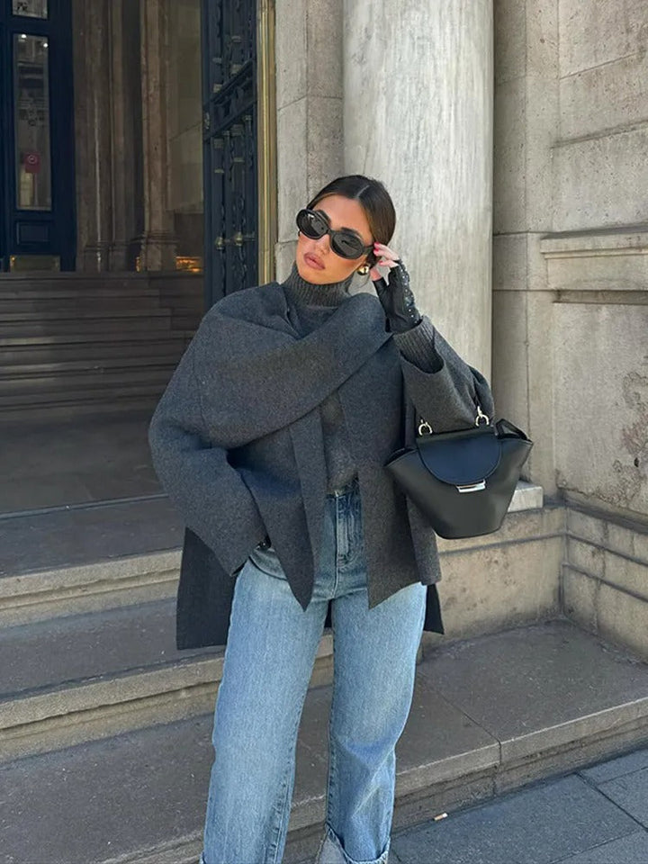 Close-up of elegant women's drape cape coat showcasing its asymmetrical hem and fluid, effortless style.
