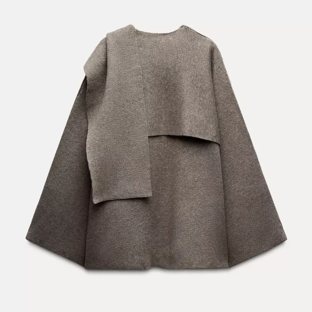 Woman wearing a sophisticated drape cape coat, styled for a chic fall fashion look. Elegant transitional outerwear.