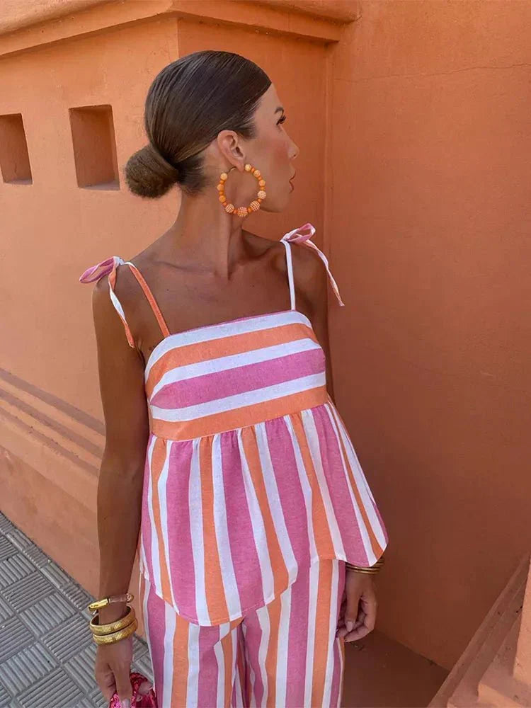 Chic women's striped wide leg wedding guest outfit. Two-piece set with a stylish peplum top for summer events.
