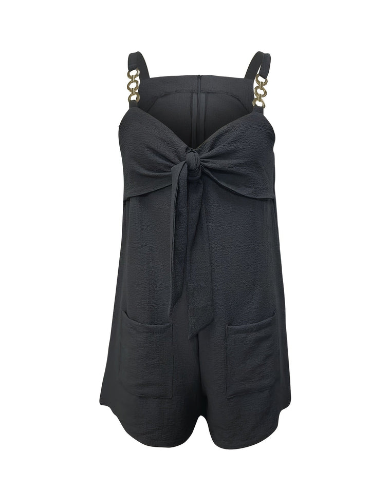 Women's fashion textured romper with a flattering sweetheart neckline, chain straps, & charming bow.