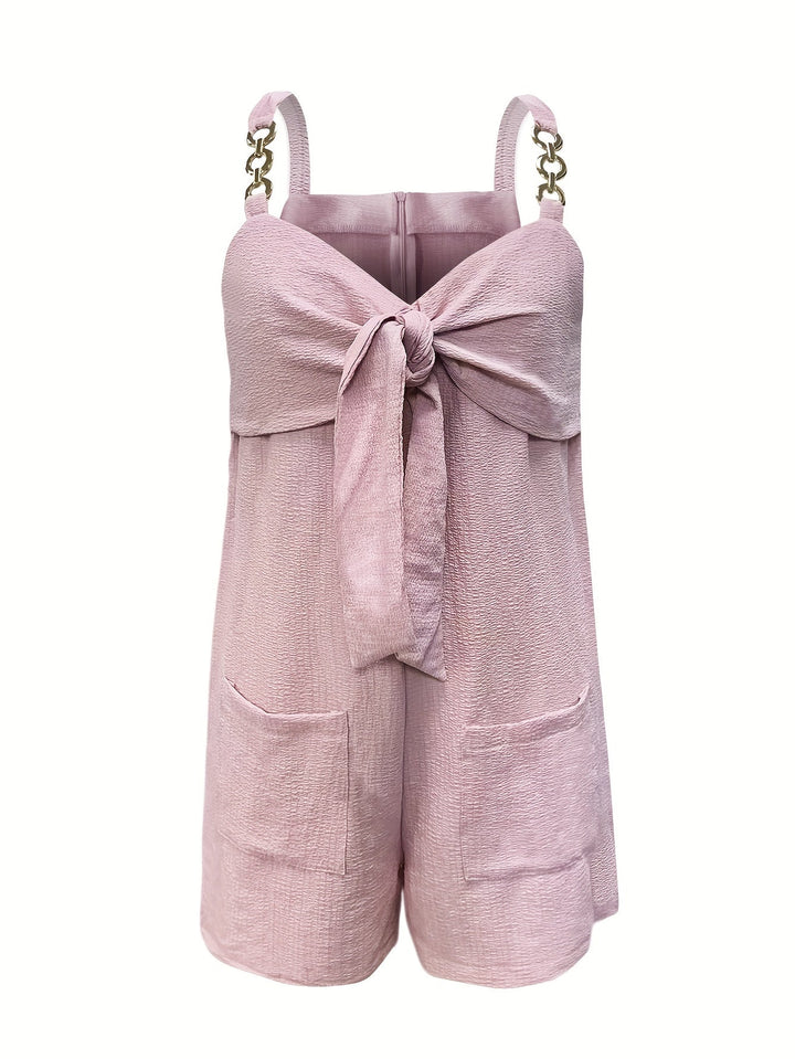 Women's summer textured romper styled with accessories, emphasizing chain straps, bow, and fashion appeal.